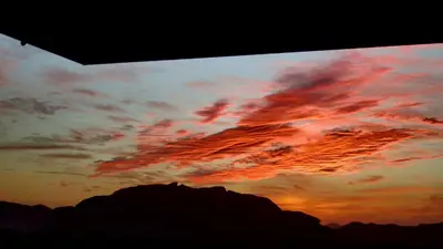 a sunset in the sky over a mountain at Salem Camp in Wadi Rum