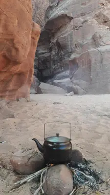 a pot sitting on a campfire in the desert at Salem Camp in Wadi Rum
