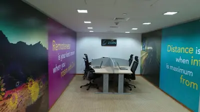 an office with a table with chairs and signs at Amman Airport Hotel in Al Qasţal