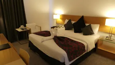 a hotel room with a large bed in a room at Amman Airport Hotel in Al Qasţal