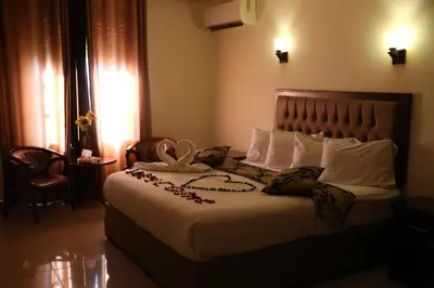 a bedroom with a bed with a flower on it at Grape Village Hotel in Amman