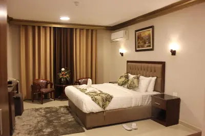 a hotel room with a bed and a chair at Grape Village Hotel in Amman