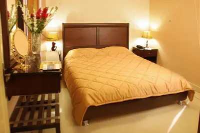 a bedroom with a bed and a table with a mirror at Jardaneh Hotel in Aqaba