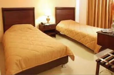 a hotel room with two beds and a desk at Jardaneh Hotel in Aqaba