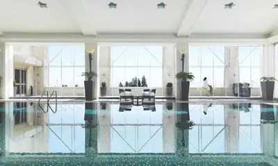 a pool in a building with a person swimming at Four Seasons Hotel Amman in Amman