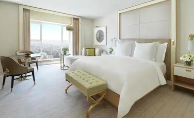 a bedroom with a large white bed and a desk at Four Seasons Hotel Amman in Amman