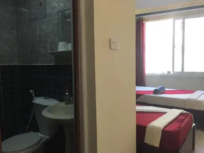 a bathroom with a sink and a toilet and a bed at Nobel Hotel in Amman