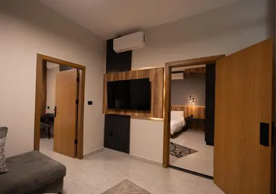 a room with a bed and a television in a room at Al Jawhara Hotel Suites in Amman