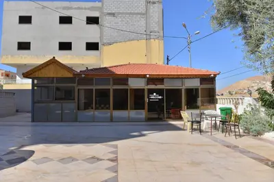 a building with a table and chairs in a courtyard at Juniper House in Wadi Musa
