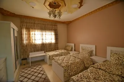 a bedroom with two beds and a chandelier at Juniper House in Wadi Musa