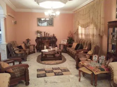 a living room filled with furniture and a chandelier at Murshed Motel in Ash Shūnah ash Shamālīyah