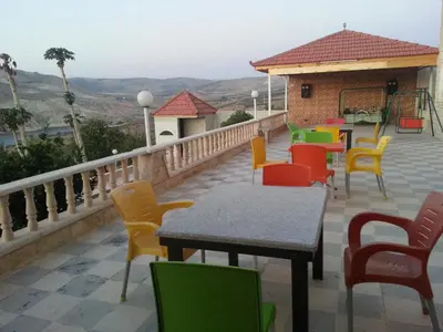 a patio with colorful chairs and tables on a balcony at Murshed Motel in Ash Shūnah ash Shamālīyah