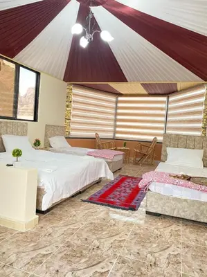 a bedroom with two beds and a tent at Bronze Mountains Camp Wadi Rum in Aqaba