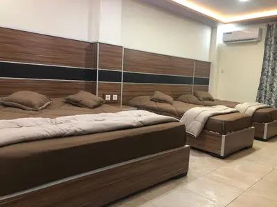 a row of beds in a room with at Al Deyafa Hotel in Aqaba
