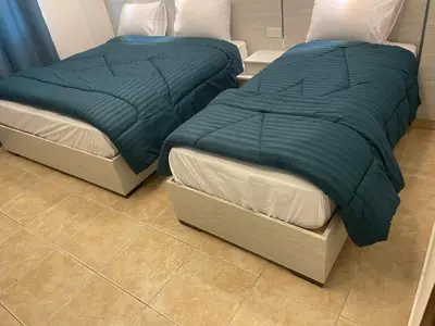 two beds sitting next to each other in a room at Al Deyafa Hotel in Aqaba