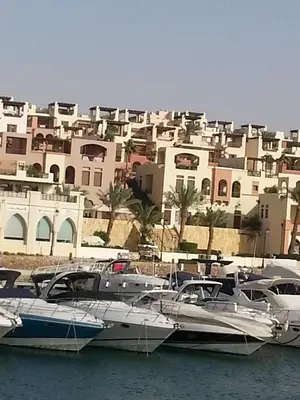 a group of boats docked in the water in front of buildings at Sea View Apartment at Tala Bay Resort in Aqaba in Aqaba