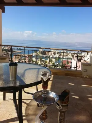 a table on a balcony with a view of the ocean at Sea View Apartment at Tala Bay Resort in Aqaba in Aqaba