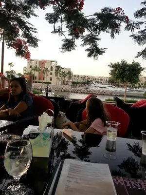 a group of people sitting at a table in a restaurant at Sea View Apartment at Tala Bay Resort in Aqaba in Aqaba