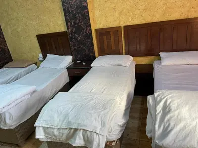 a group of three beds in a room at Aqaba Roza in Aqaba