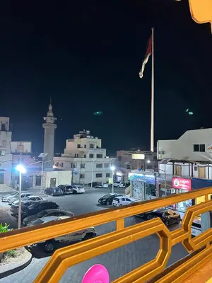 a view of a parking lot at night with a flag at Relax House For Studio Rooms Apartments ريلاكس هاوس للشقق المفروشة in Aqaba