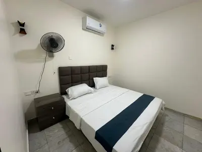 a bedroom with a bed and a fan at Relax House For Studio Rooms Apartments ريلاكس هاوس للشقق المفروشة in Aqaba