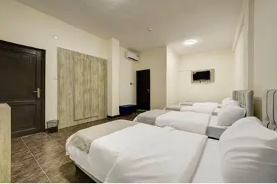 a room with four beds and a tv in it at Hotel magic aqaba in Aqaba