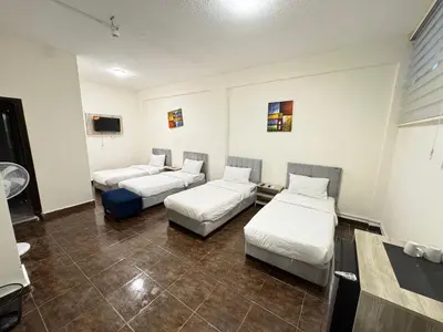 a room with three beds and a tv at Hotel magic aqaba in Aqaba
