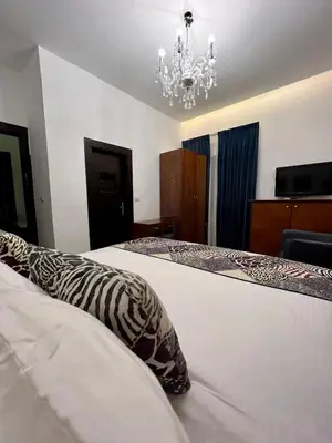 a bedroom with two beds and a chandelier at Bonita Inn in Amman