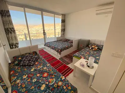 a small room with two beds and a window at Jordan Guest House in Wadi Musa