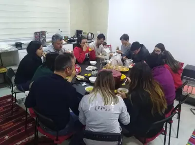 a group of people sitting around a table eating food at Jordan Guest House in Wadi Musa