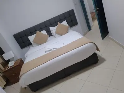 a bed with white sheets and pillows in a room at Shami Plaza Hotel in Amman
