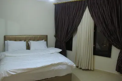a bedroom with a bed and a window with curtains at Shami Plaza Hotel in Amman