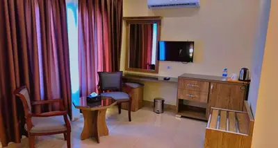 a room with a desk and a tv and a chair at Shaqilath Hotel in Wadi Musa