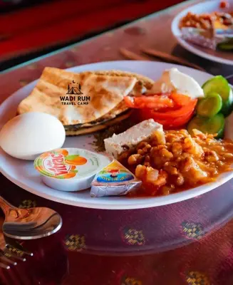 a plate of food with eggs bread and vegetables at Wadi Rum Travel camp in Wadi Rum