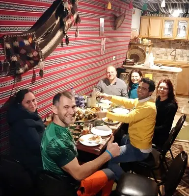 a group of people sitting around a table eating food at Majido Hotel in Wadi Musa