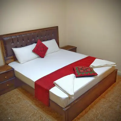 a bed with red and white pillows on it at Majido Hotel in Wadi Musa