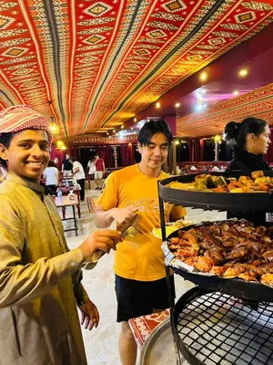 two people standing next to a table with food at Bedouin host camp& with tour in Wadi Rum