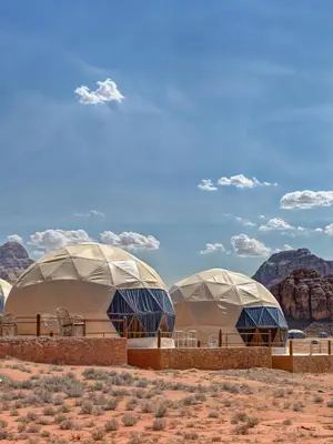 three domes in the desert with mountains in the background at Rum Paradise luxury camp& BUBBLE in Wadi Rum
