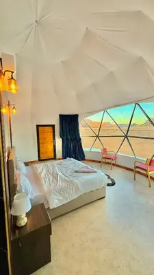 a bedroom with a bed and a large tent at Rum Paradise luxury camp& BUBBLE in Wadi Rum