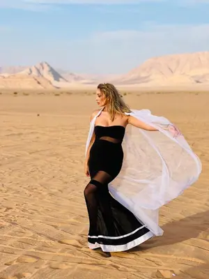 a woman in a dress is standing in the desert at Rum Paradise luxury camp& BUBBLE in Wadi Rum