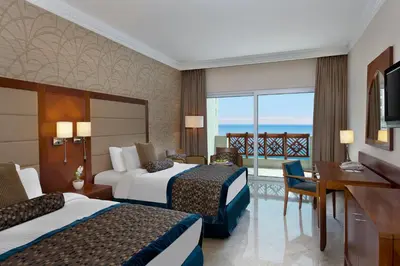 a hotel room with two beds and a desk at Crowne Plaza Jordan Dead Sea Resort & Spa by IHG in Sowayma