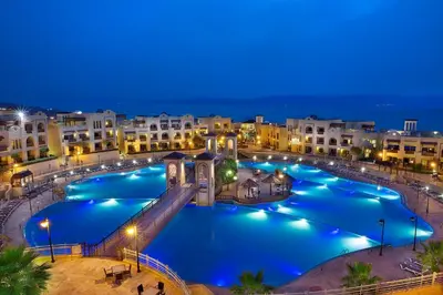 a large pool in a city at night at Crowne Plaza Jordan Dead Sea Resort & Spa by IHG in Sowayma
