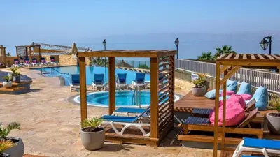 a resort with a swimming pool and a beach at Crowne Plaza Jordan Dead Sea Resort & Spa by IHG in Sowayma