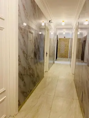 a hallway with marble walls and a hallway with doors at Arabesque Hotel in Amman