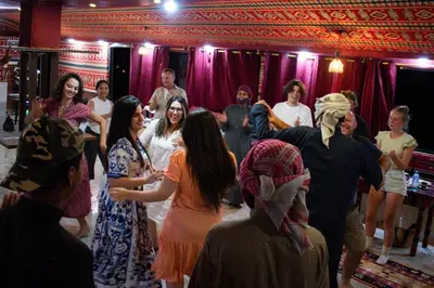 a group of people dancing in a room at Wadi Rum Magic Nature Camp in Wadi Rum