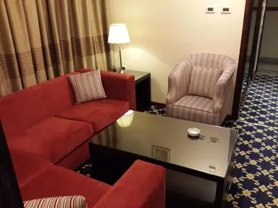 a living room with a couch and two chairs at Al Thuraya Hotel in Amman
