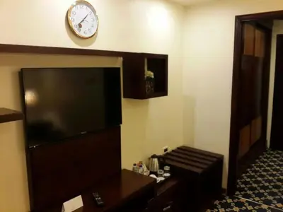 a room with a tv and a clock on the wall at Al Thuraya Hotel in Amman