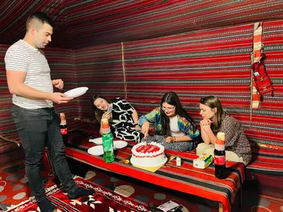 a group of people sitting around a table with a cake at Desert Tree camp&tours in Wadi Rum