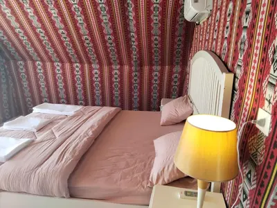 a bed in a room with a lamp at Mujib Castle Gate Camp in Dhībān