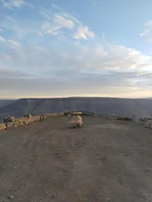 a sheep sitting on the top of a mountain at Mujib Castle Gate Camp in Dhībān